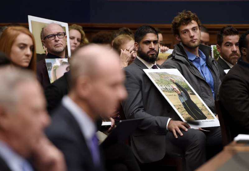 Family members of those who died aboard Ethiopian Airlines Flight 302 hold photographs of their loved ones during Muilenburg's t
