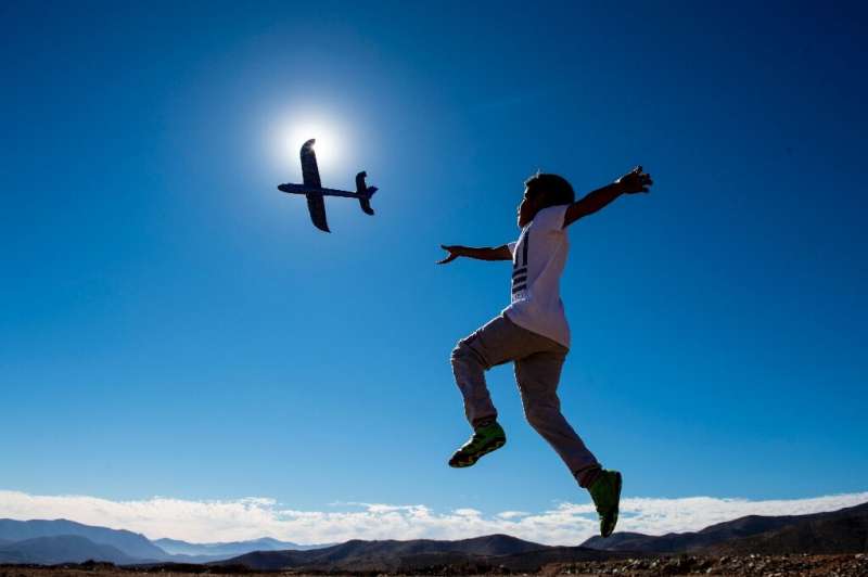 A boy plays with a toy glider on the eve of a solar eclipse, in La Higuera on the edge of the Atacama desert