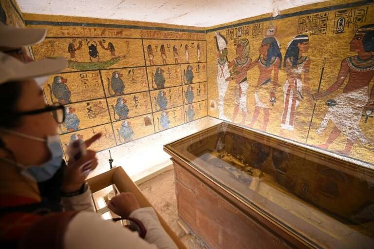 A man and a woman look at the golden sarcophagus of the 18th dynasty Pharaoh Tutankhamun, displayed in his burial chamber in the