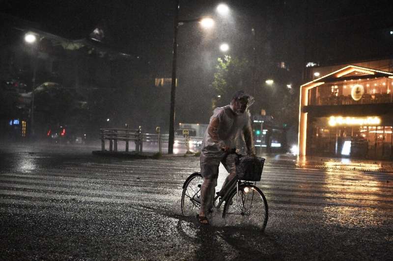 A man in Tokyo rides his bicycle during Typhoon Faxai, which made landfall just east of the Japanese capital
