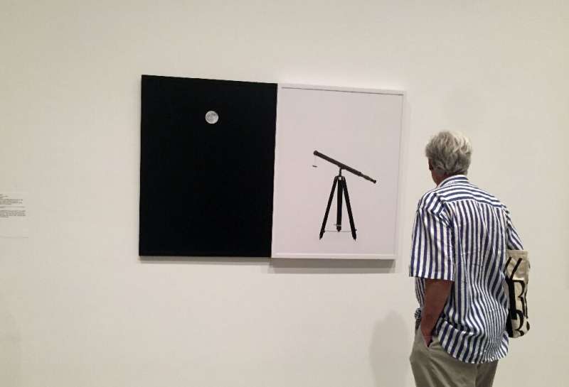 A man looks at Maurice Loewy and Pierre Henri Puiseux's &quot;Photographic Atlas of the Moon&quot; on July 1, part of a new exhi