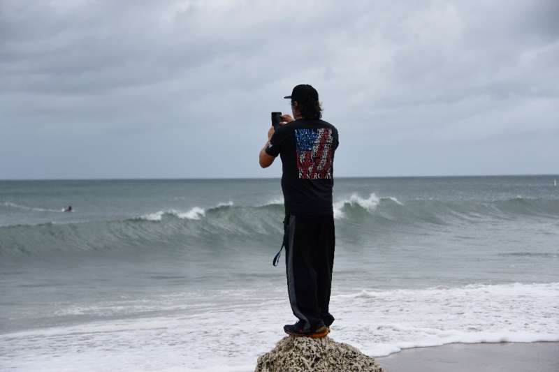 A man takes a photo of the sea as Hurricane Dorian approaches in Deerfield Beach, Florida on September 2, 2019