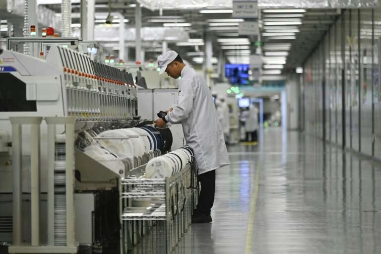 An employee works on a mobile phone production line at a Huawei production base during a media tour in Dongguan