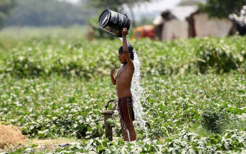 An Indian boy tries to cool off by dousing himself with water in New Delhi on May 29, 2019 during a heatwave