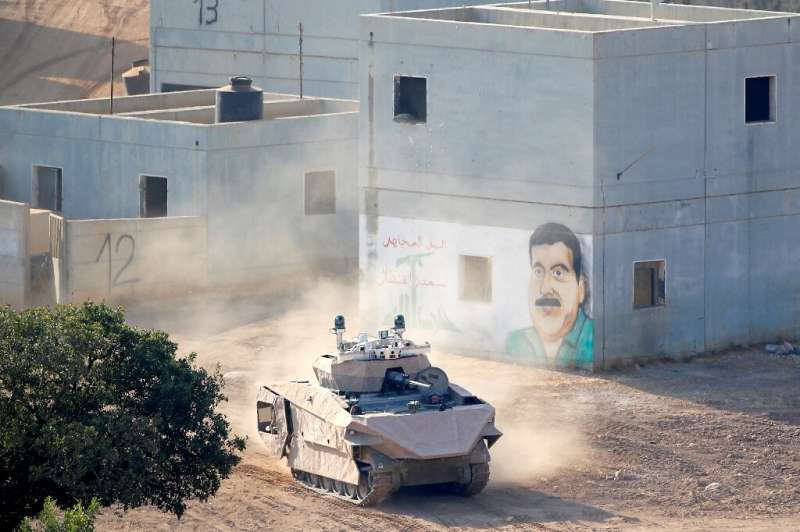 An Israeli tank drives through a mock Arab village used for battle training, at a base in northern Israel