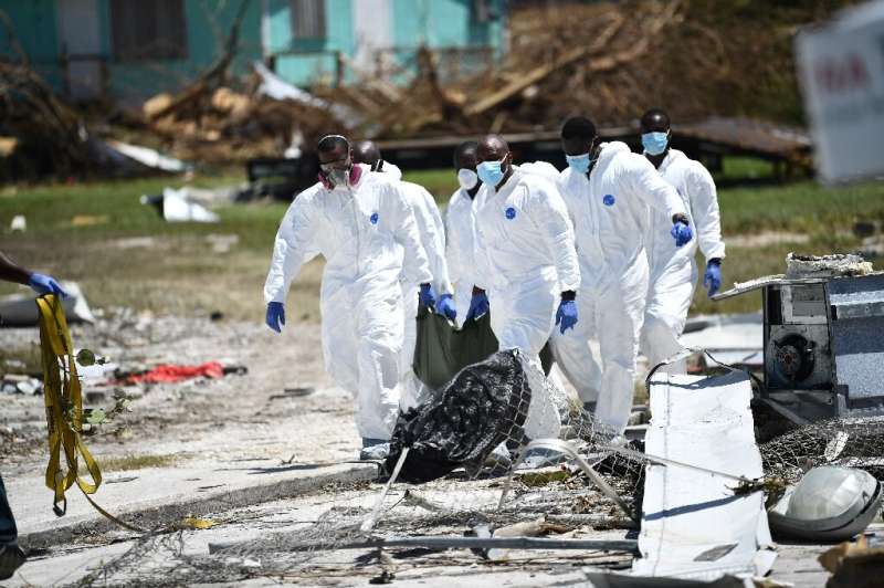 A removal team carries a victim in a body bag on Great Abaco island in the Bahamas