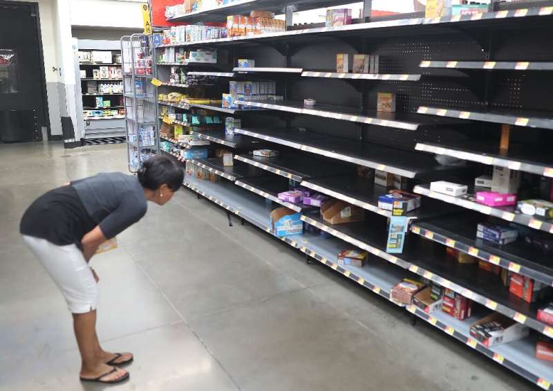 A shopper looks for items on nearly empty Walmart shelves in Boynton Beach ahead of the arrival of Hurricane Dorian