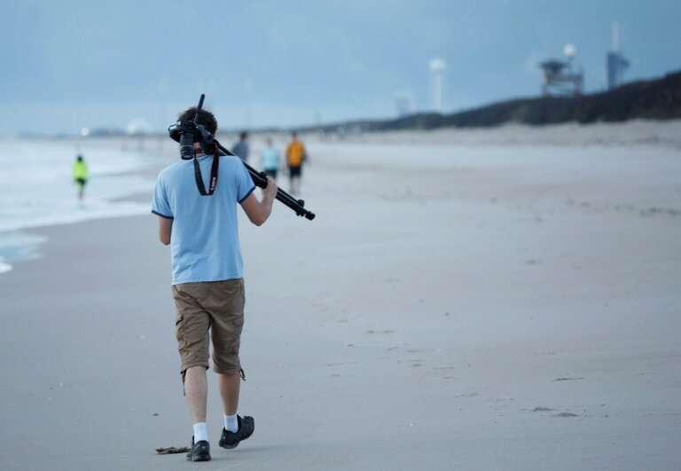A visitor on a beach just north of the Kennedy Space Center in Florida, looking for a good vantage point to capture the launch o
