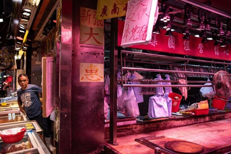 A worker looks out from a meat stall after fresh pork sold out in the Mong Kok district in Hong Kong