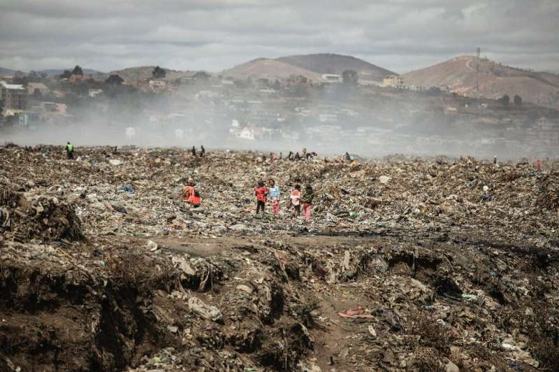 Children and waste pickers sift through garbage at a landfill near 'Cite Akamasoa' - 'Akamasoa Town'