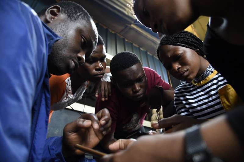 Code for Africa's John Eromosele, left, teaches volunteers how to use the app for the digital mapping project