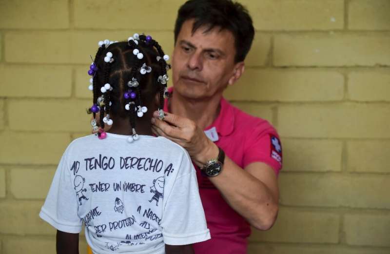Colombian doctor Carlos Melo, who works on the hospital ship, examines a girl at a community on the banks of the San Juan river