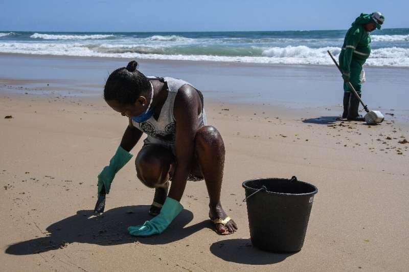 Council workers scrape spilled crude off the beach in Itapuama in northeastern Brazil as the country rushes to prepare for the p
