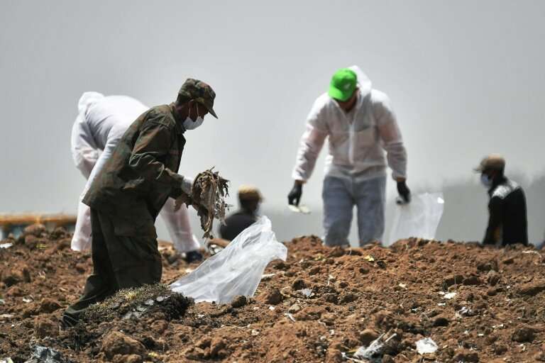 Forensic experts comb through the dirt for debris at the crash site of the Ethiopian Airlines Boeing 737 MAX 8 aircraft