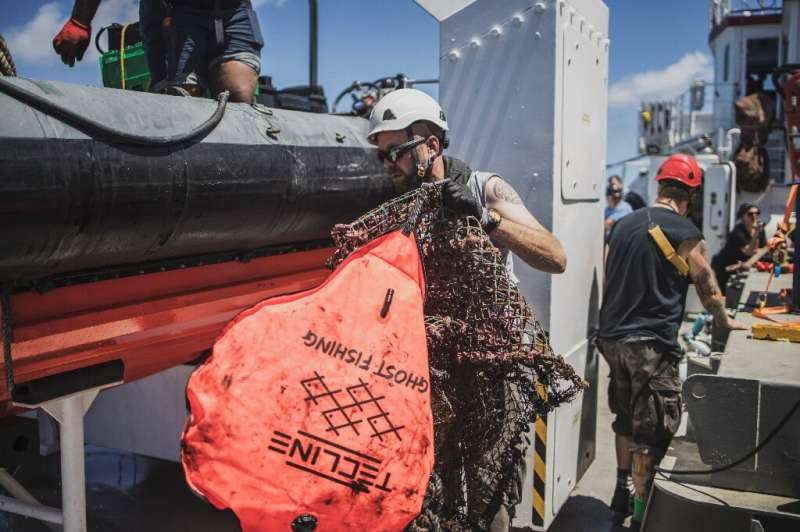 Ghost hunt: A Greenpeace crew member retrieves a device to identify abandoned nets and other fishing equipment. 'Ghost gear' is 