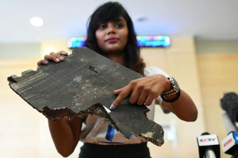 Grace Subathirai Nathan, daughter of Malaysian Airlines flight MH370 passenger Anne Daisy, shows debris believed to be from the 