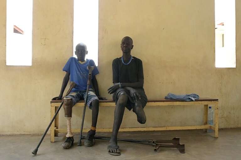 Gunshot wound survivors Jal Keat, 12, left, and Nyagn Thyuong, wait at the Red Cross rehabilitation centre in Juba