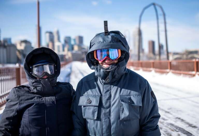 Jen Brackman and Aaron Brackman don heavy jackets and goggles while on a walk on the Stone Arch Bridge in Minneapolis, Minnesota