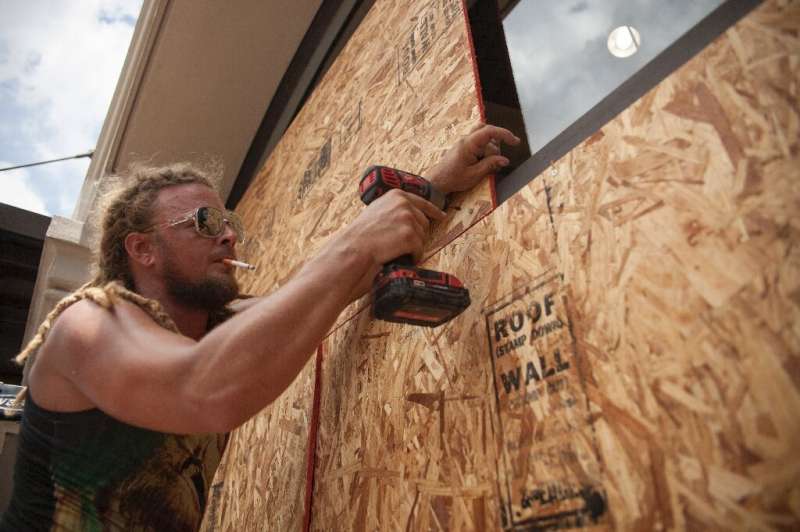 Matt Harrington boards up a Vans shoe store near the French Quarter in New Orleans as tropical storm Barry approaches