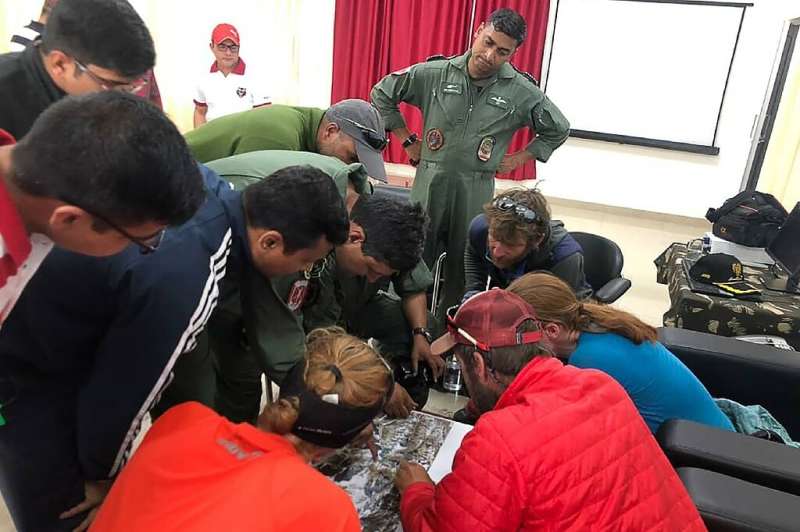 Mountaineers and rescuers study a map of Nanda Devi in an effort to pinpoint the location of the missing climbers on June 3, 201