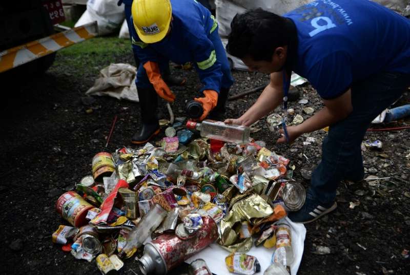 Nepali workers search for recyclable materials from a a pile of waste collected from Mount Everest