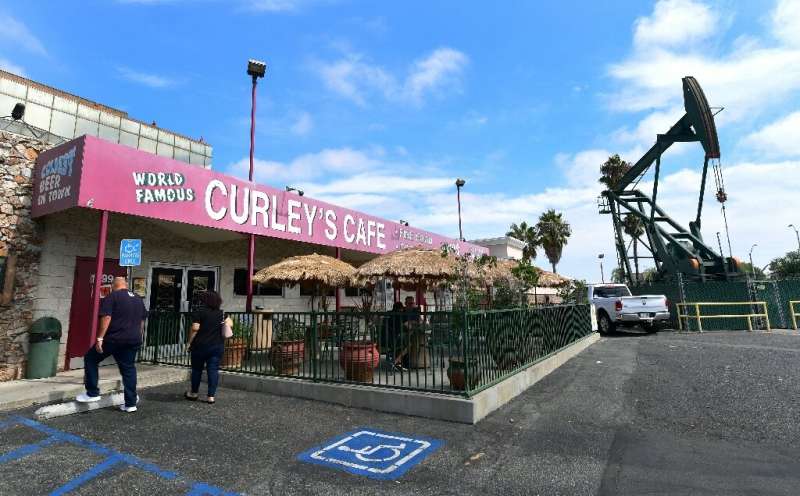 People make their way into Curley's Cafe in Signal Hill, which sits in the shadow of a pumpjack