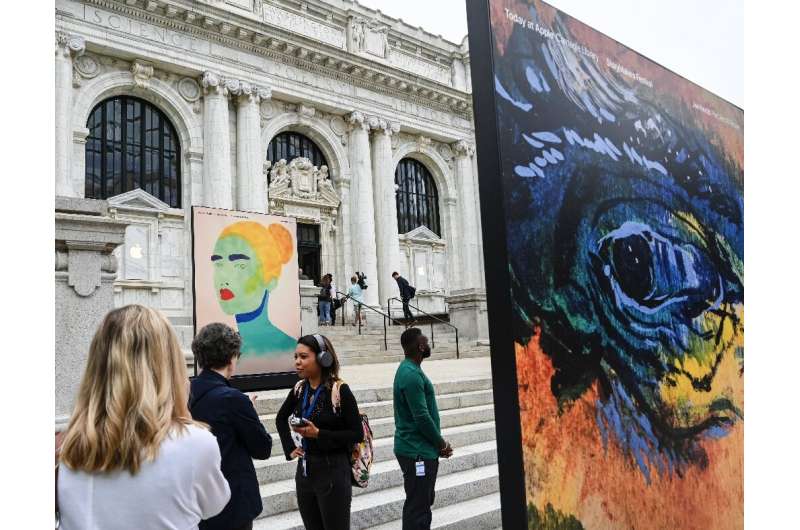 People stand around the 1903 Carnegie Library renovated by Apple, set to reopen with a retail store operated by the tech giant a