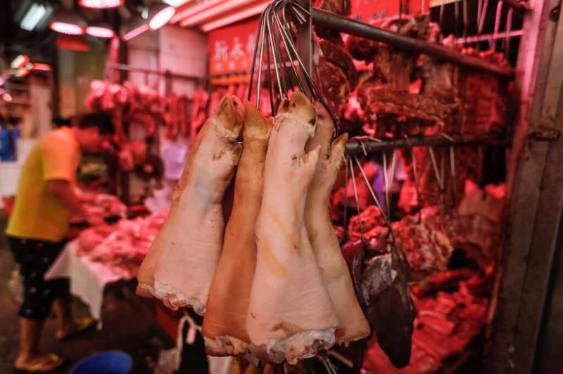 Pig trotters hang from hooks at a meat market in Hong Kong, where the price of pork has soared since the outbreak of African swi