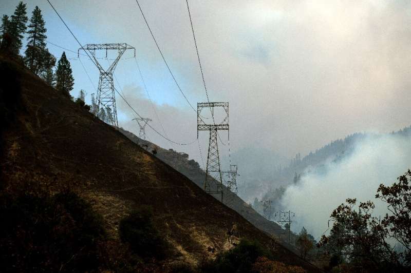 Power lines are seen on November 11, 2018 against a smoky landscape near Pulga, California, east of Paradise, California