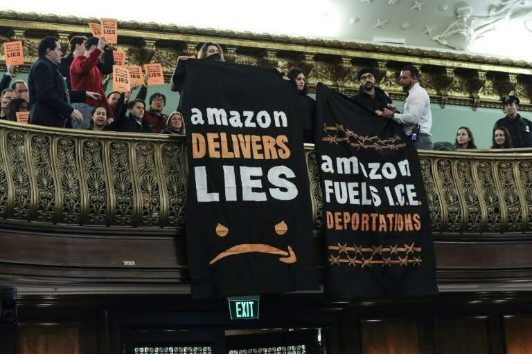 Protestors unfurl anti-Amazon banners from the balcony of a hearing room during a New York City Council finance committee hearin