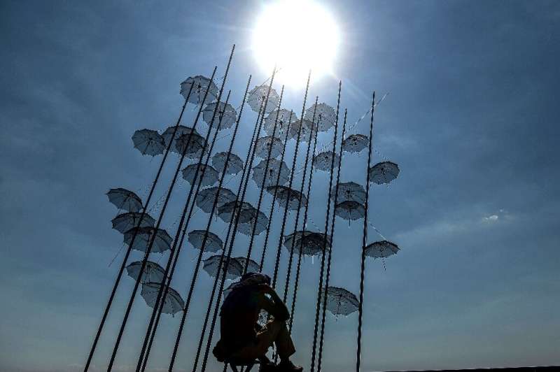 &quot;Umbrellas&quot; by Greek sculptor George Zongolopoulos provide little respite from sizzling June temperatures