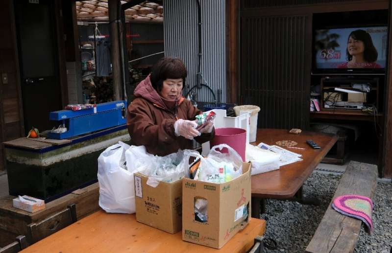 Saeko Takahashi, 71, separates trash into different boxes at her home in Kamikatsu and uses a compost bin for food waste