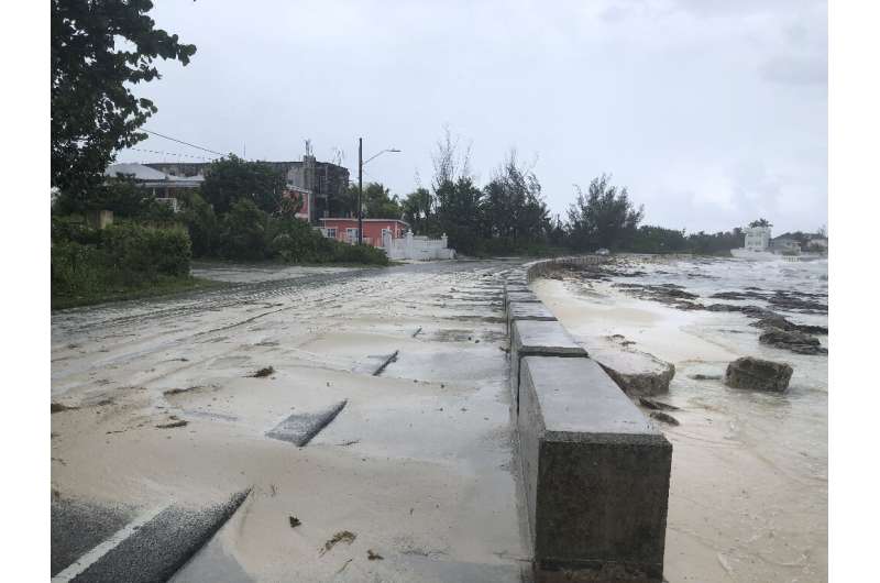 Sand pours onto a road near the beach in Nassau, Bahamas during the approach of Hurricane Dorian