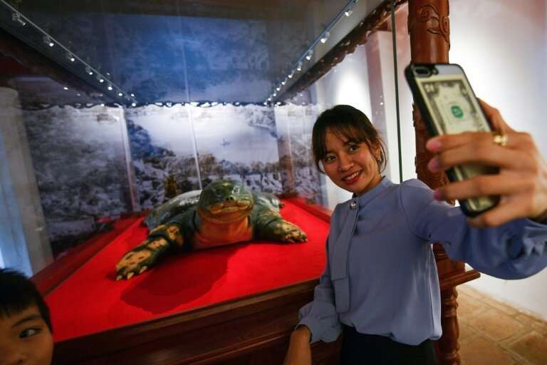 Say cheese: A woman takes selfie with a sacred giant turtle embalmed in Hanoi after its 2016 death