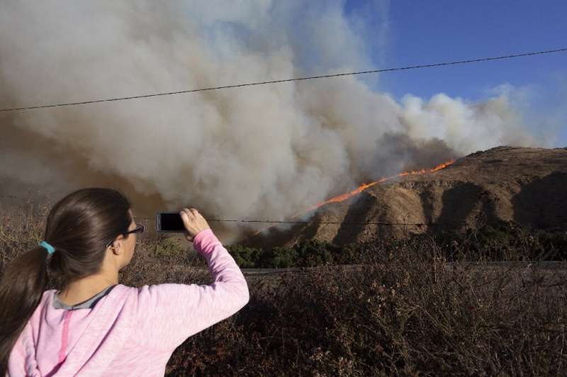 SIMI VALLEY, CA - OCTOBER 30: A woman looks on as the Easy Fire approaches on October 30, 2019 near Simi Valley, California.