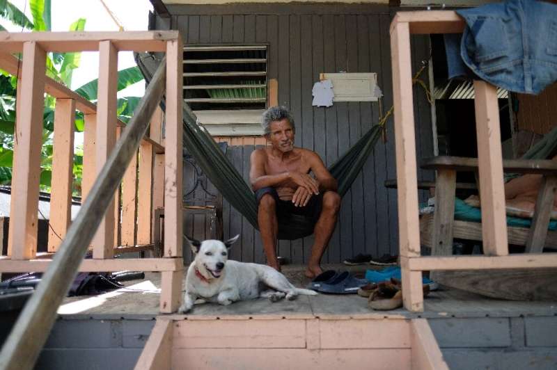 Sixto Marrero sits on the porch of his home in Puerto Rico, two years after its roof was ripped off by Hurricane Maria