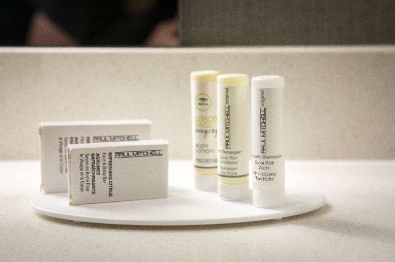 Small plastic bottles of shampoo, conditioner and body lotion sit in a bathroom in a room at a SpringHill Suites, a hotel operat
