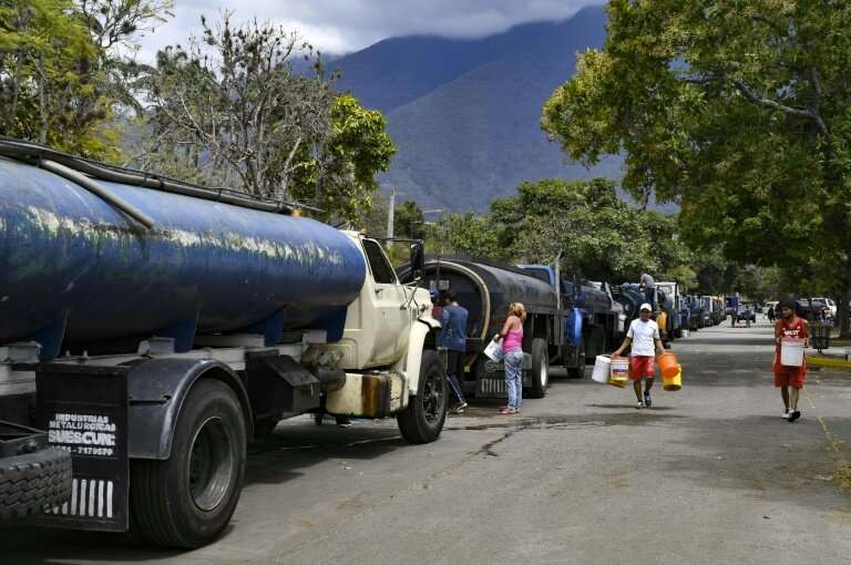 Tanker trucks line up as residents fill drums and buckets with drinking water in Caracas—just another indignity of Venezuela's c