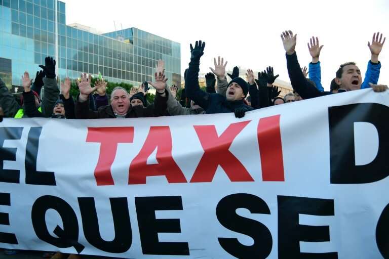 Taxi drivers blocked the road in Madrid outside one of the world's biggest tourism fairs, burning tyres and a dustbin