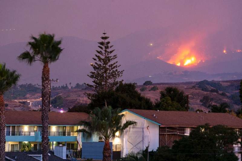 The Cave fire burns a hillside above houses in Santa Barbara, California on November 26, 2019ing homes.