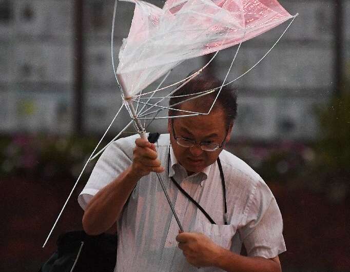 This umbrella provided little shelter for a man crossing a street in Tokyo during Typhoon Faxai