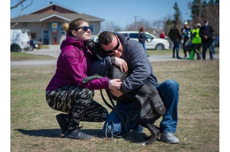 Tourangeau hug their pet dog Harley after he was rescued from the flooded Canadian town of Sainte-Marthe-sur-le-Lac