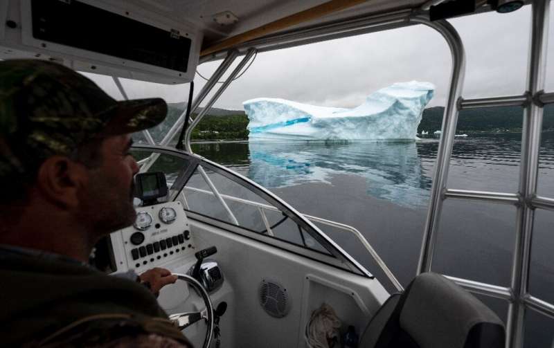 Tour guide and former fisherman Barry Strickland steers his boat near an iceberg at King's Point—iceberg tourism has been a succ