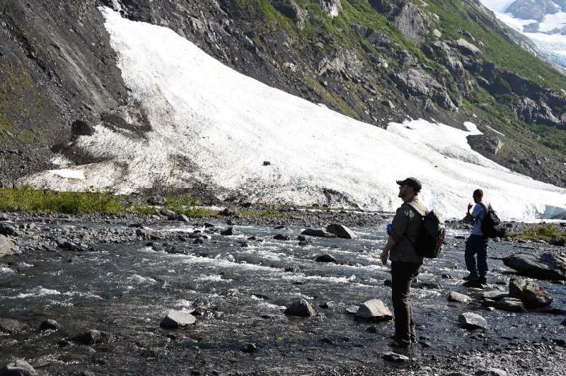 Two hikers take stock of a fast-receding glacier near Portage Lake in Girdwood, Alaska, amid record high temperatures in that no