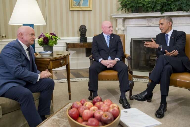 US President Barack Obama meets with NASA astronauts Scott Kelly (C) and his twin brother Mark Kelly in the Oval Office