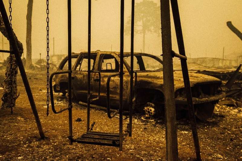 A charred swing set and car are seen after the passage of the Santiam Fire in Gates, Oregon