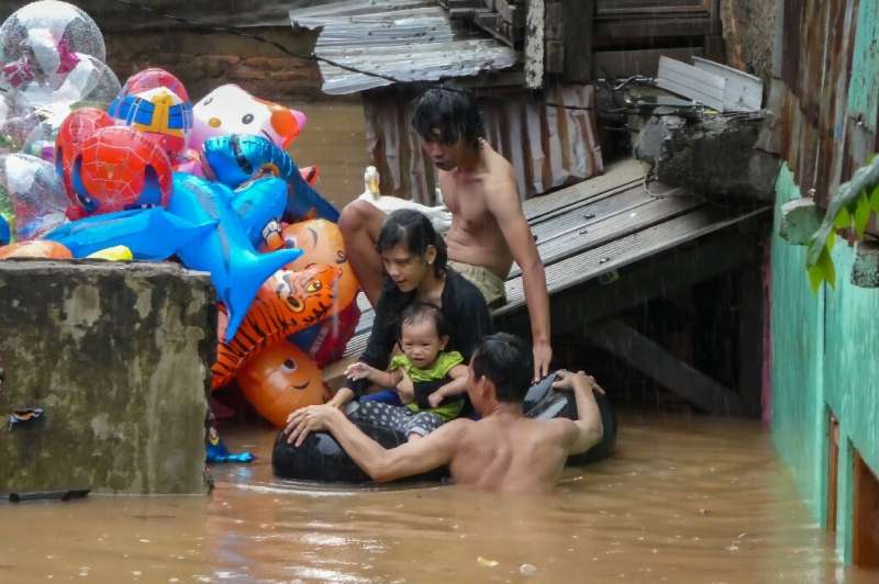 A family evacuates their home after heavy rain caused widespread flooding in Jakarta