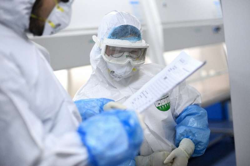 A lab technician works on samples being tested in Wuhan
