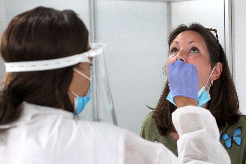 A woman is tested at a walk-in testing centre opened by German biotech company Centogene, at the airport in Frankfurt am Main