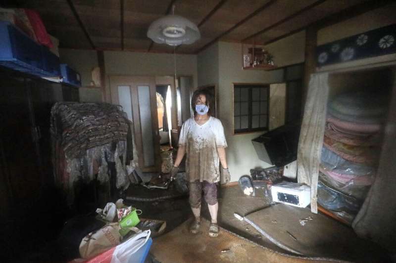 A woman stands in her flood-damaged home in  Hitoyoshi, Kumamoto prefecture